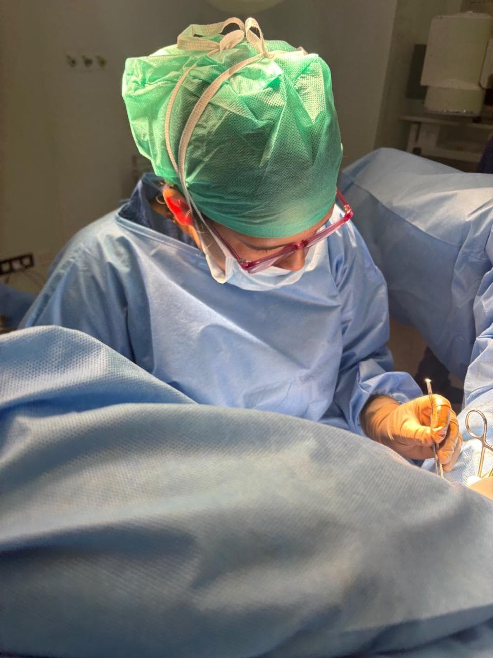 Dr. Anjani Dixit operating, seen close up over the surgical drapes