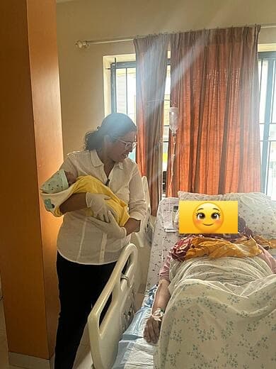 Dr. Anjani Dixit bringing a newborn to her mother at the bedside