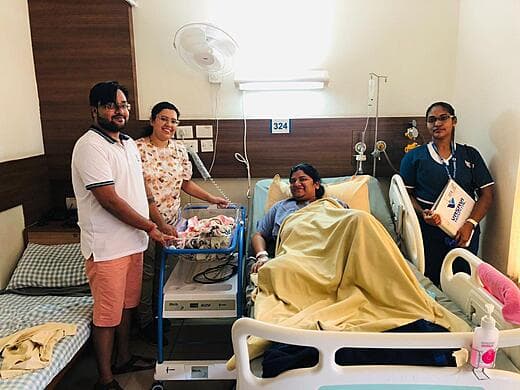 New parents with their baby beside the mother’s bed after delivery