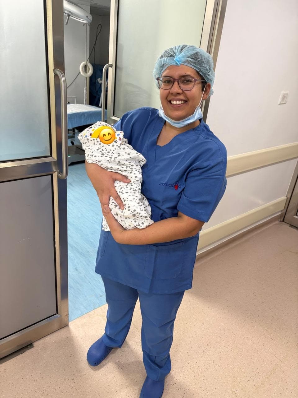 Dr. Anjani Dixit smiling in the hallway at Motherhood Hospital, holding a newborn