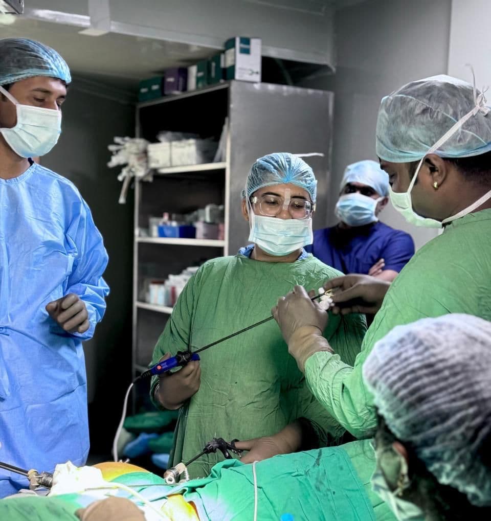 Dr. Anjani Dixit operating laparoscopically, passing an instrument to her assistant