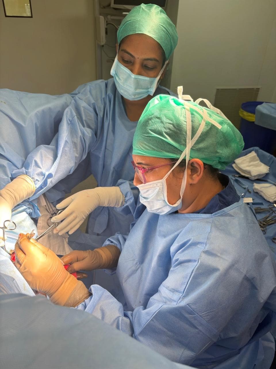 Dr. Anjani Dixit operating with a scrub nurse assisting at the table